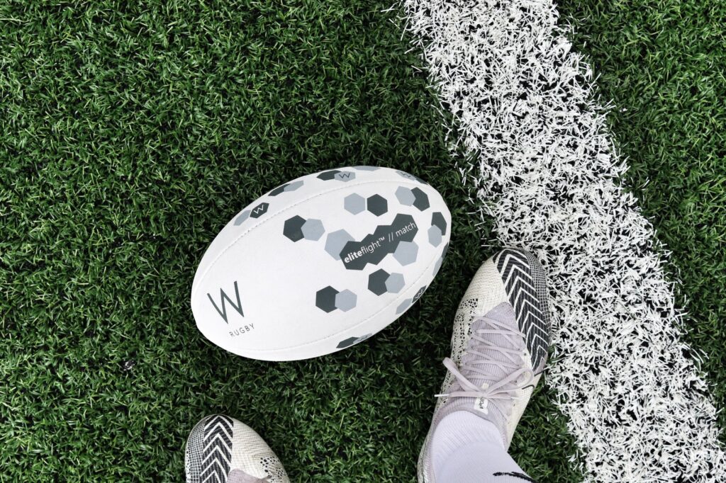 A rugby ball on the pitch during a match at a stadium