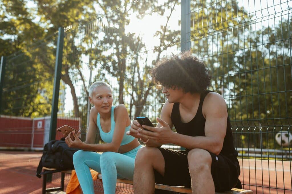 Person holding a smartphone showing a sports betting app interface