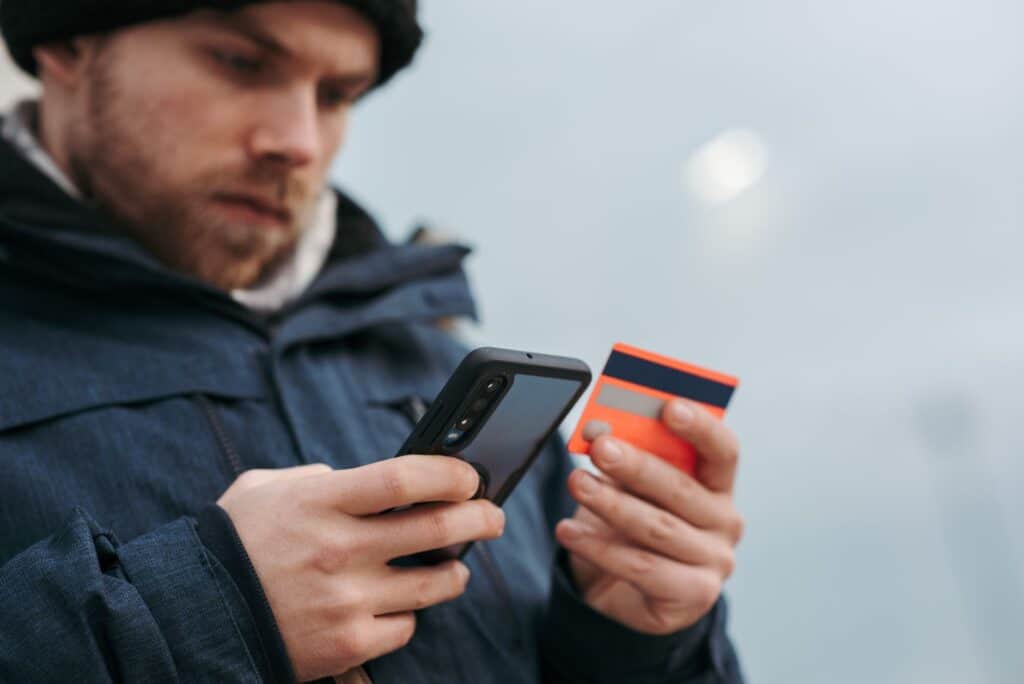 Close-up of a hand holding a smartphone showing a secure payment screen