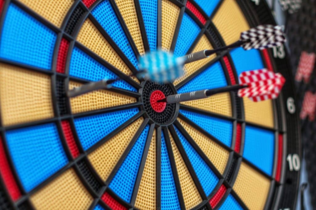 Close-up view of a dartboard with darts embedded in the surface