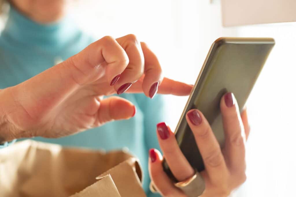 Close-up of a hand tapping a smartphone screen