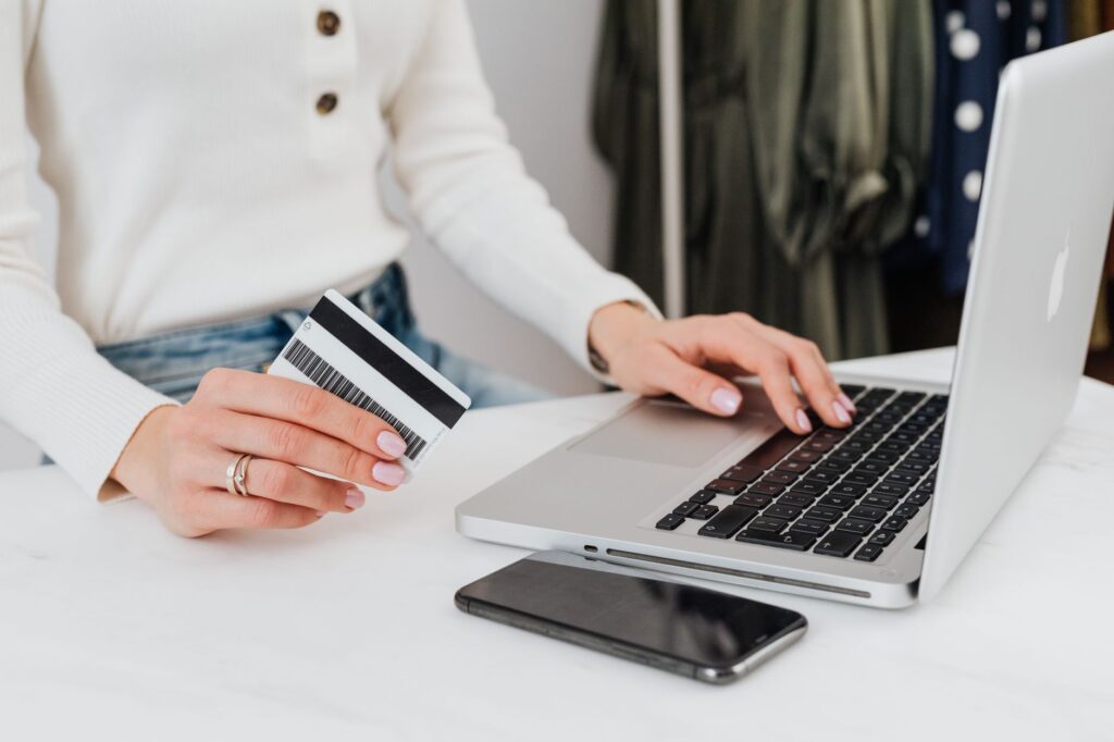 A credit card placed next to a laptop keyboard, suggesting an online payment