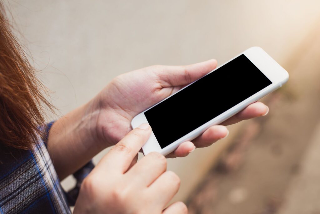Close-up of a person using a betting app on a smartphone