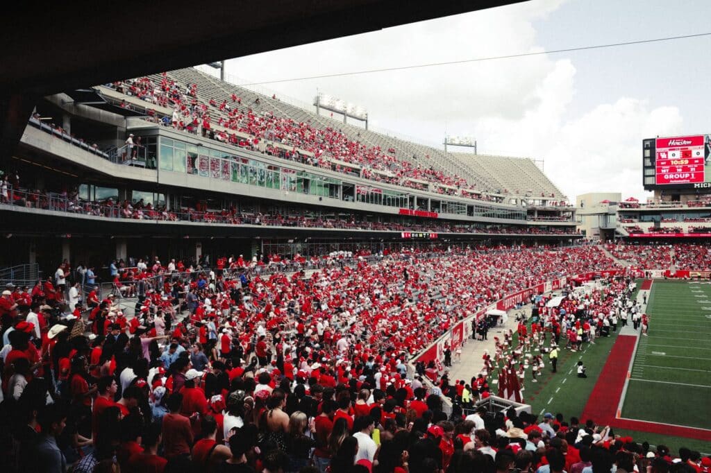 Fans watching an American football game from the stadium stands