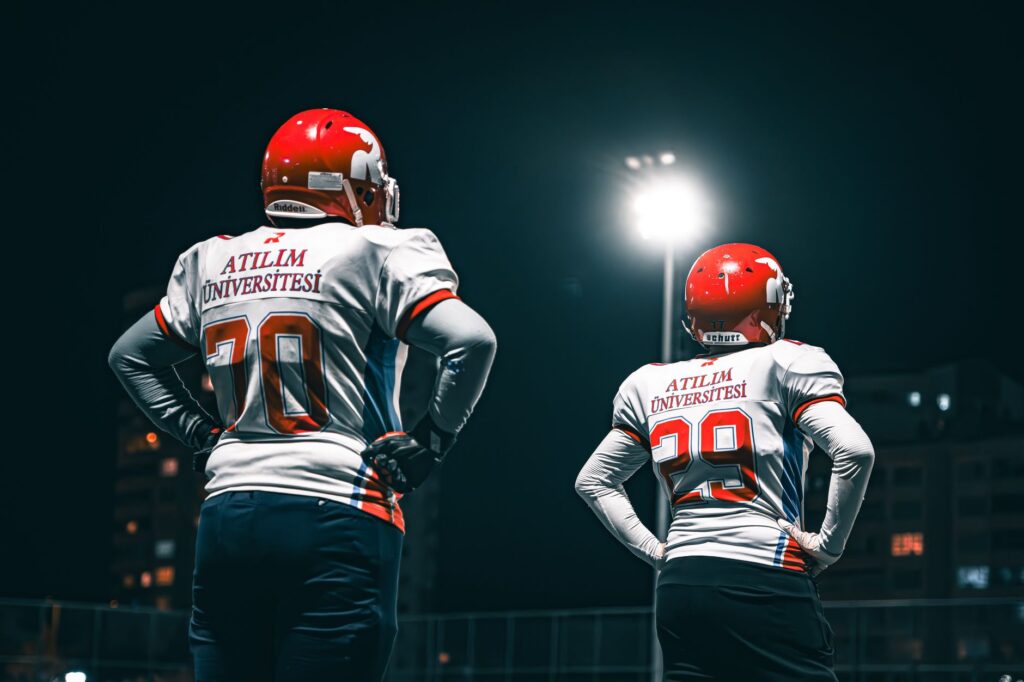 Football stadium under bright floodlights during an evening game