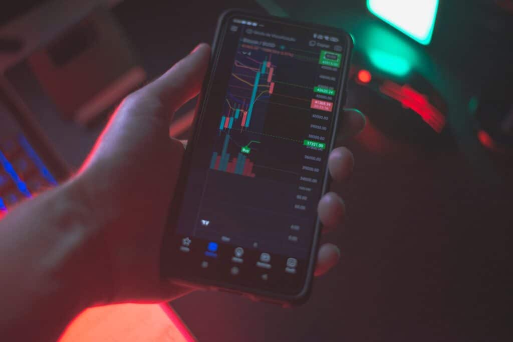 Person holding a smartphone displaying a sports betting app interface