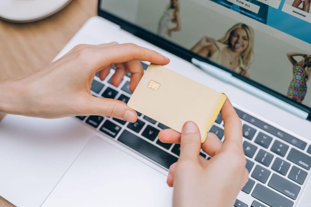 Person entering payment details on a laptop to fund an online account