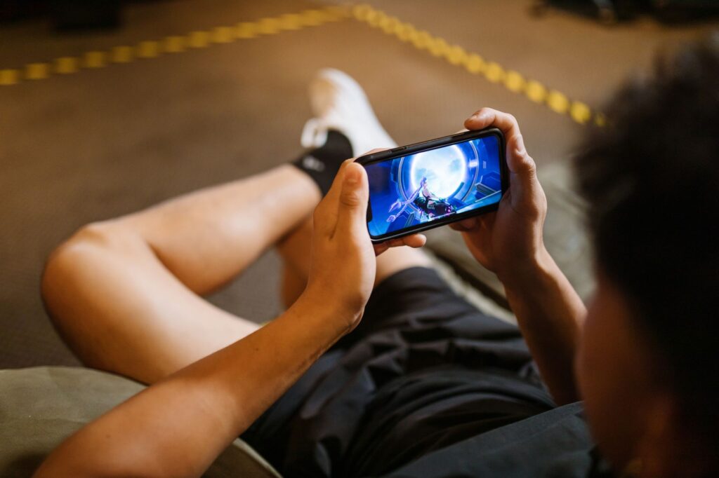 Person holding a smartphone displaying a sports betting app interface