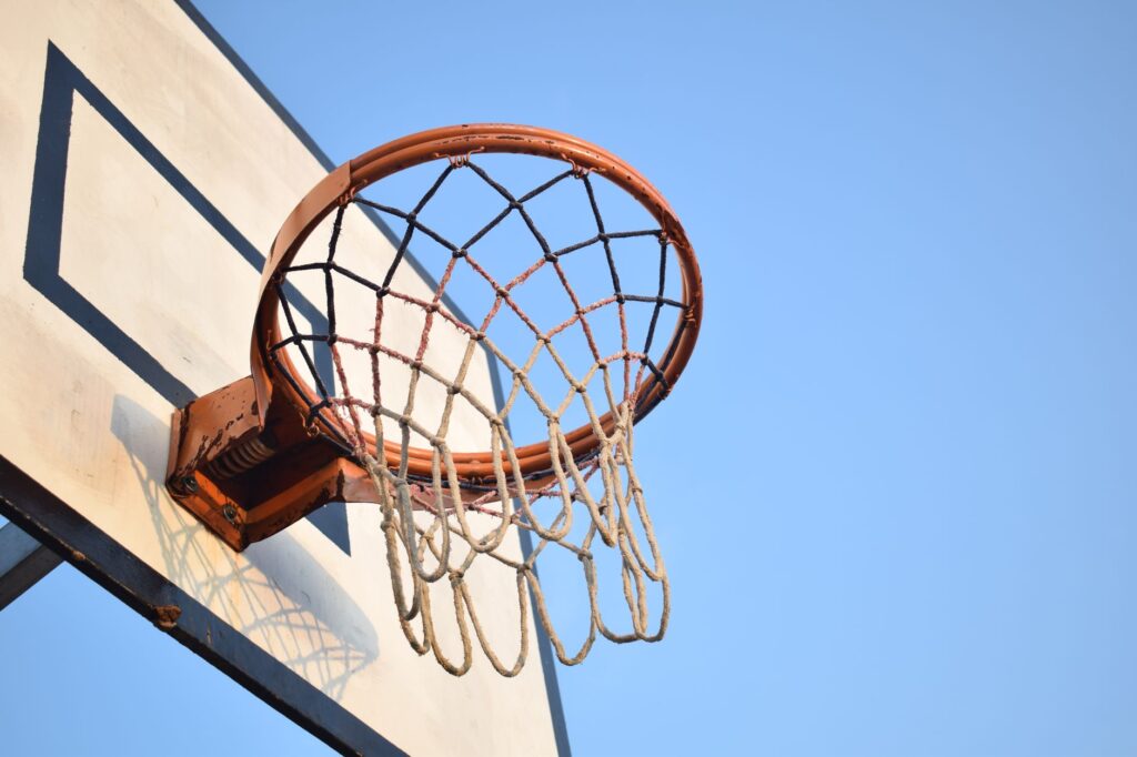 A basketball on an indoor court near the hoop