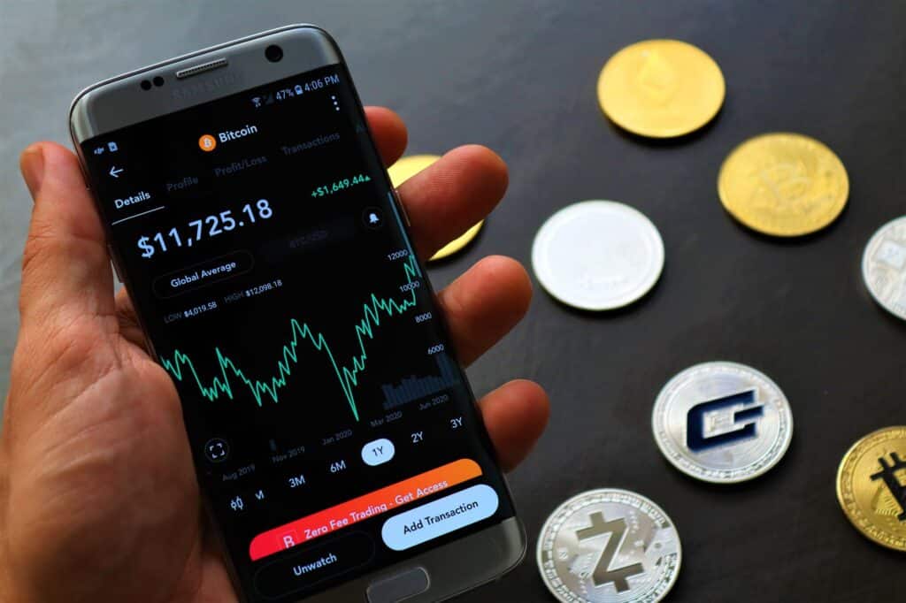 A hand holding a smartphone displaying a cryptocurrency wallet interface