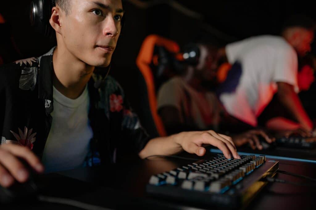 Close-up of a gaming keyboard and monitor showing an esports match in progress