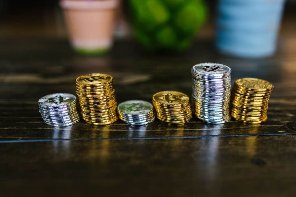 Close-up of gold and silver cryptocurrency coins on a dark surface