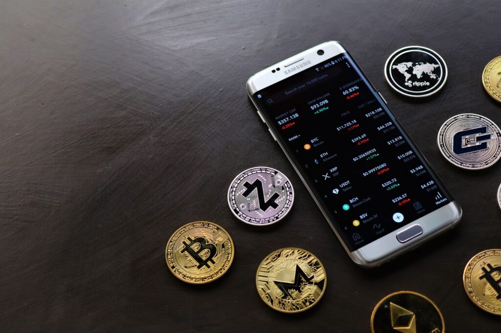 Digital cryptocurrency coins next to a smartphone showing a wallet app