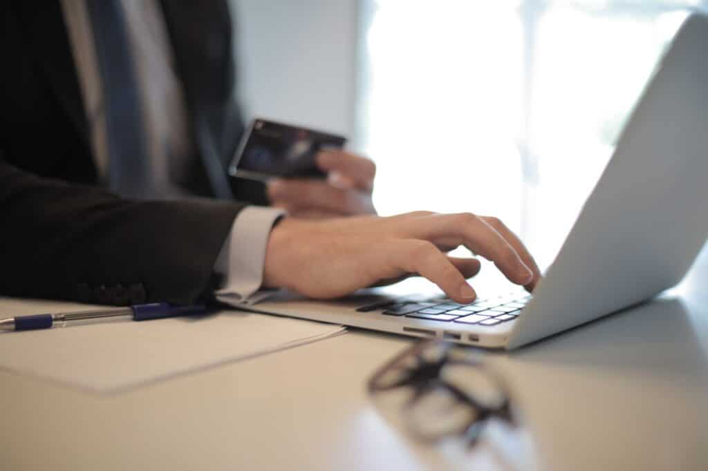 Laptop screen showing an online payment form with a card nearby