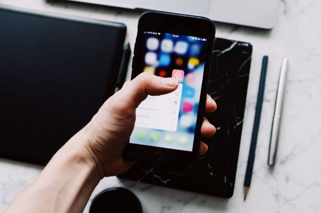 Person holding a smartphone showing a mobile app interface
