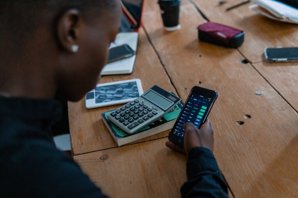 Person using a calculator and smartphone at a table