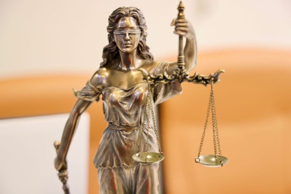 Scales of justice next to stacked law books on a desk