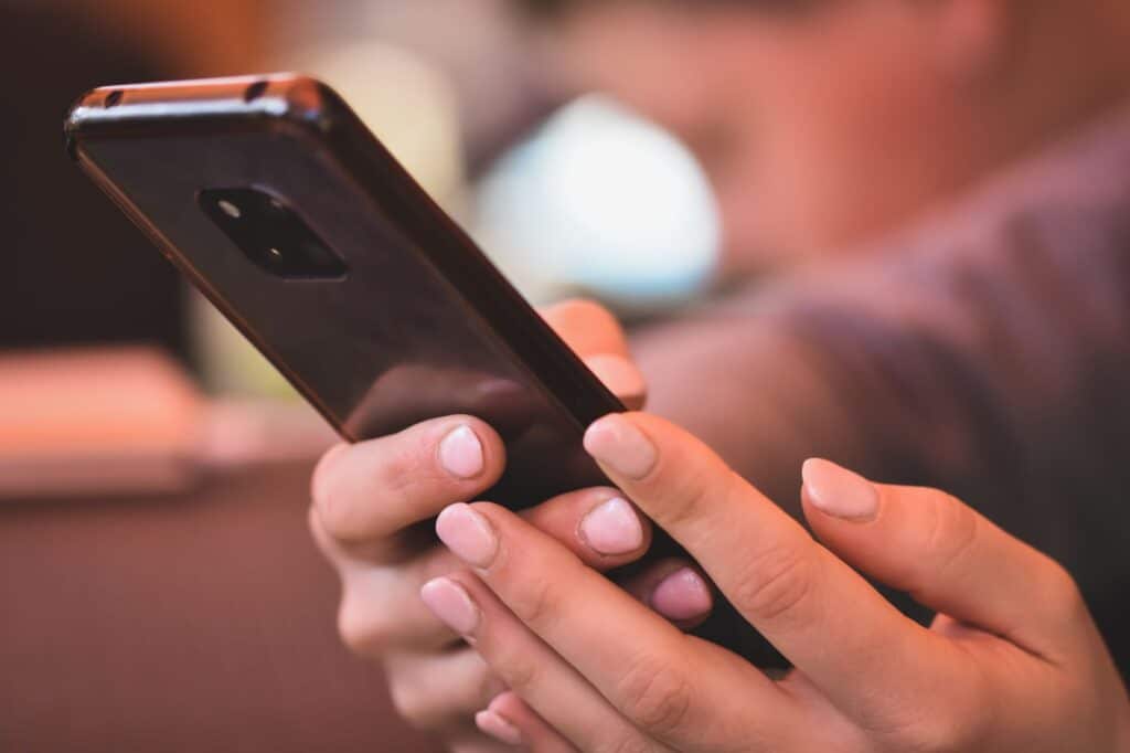 A person holding a smartphone displaying a mobile app interface